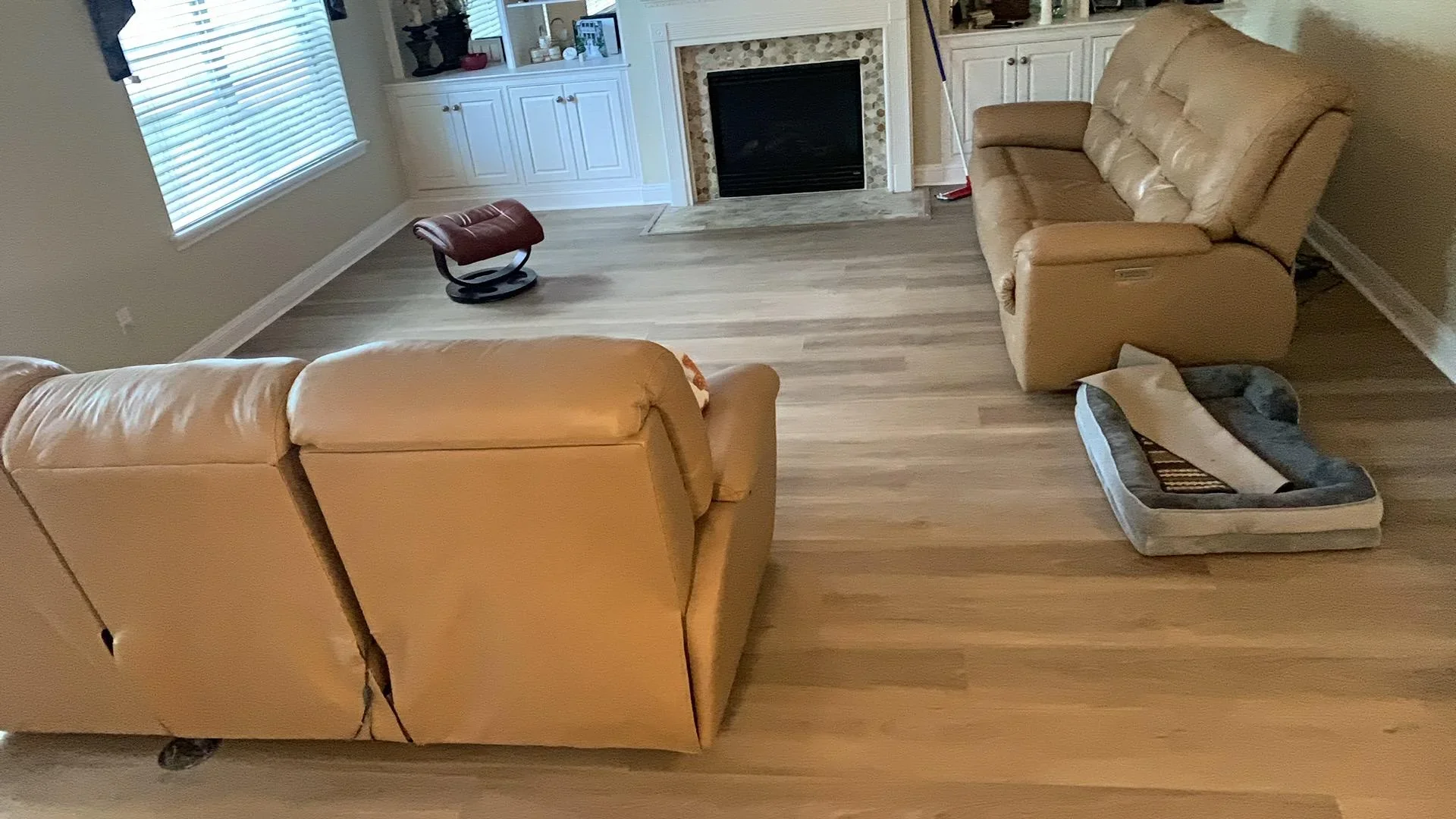 Newly installed laminate flooring with wood-grain finish in living room with furniture