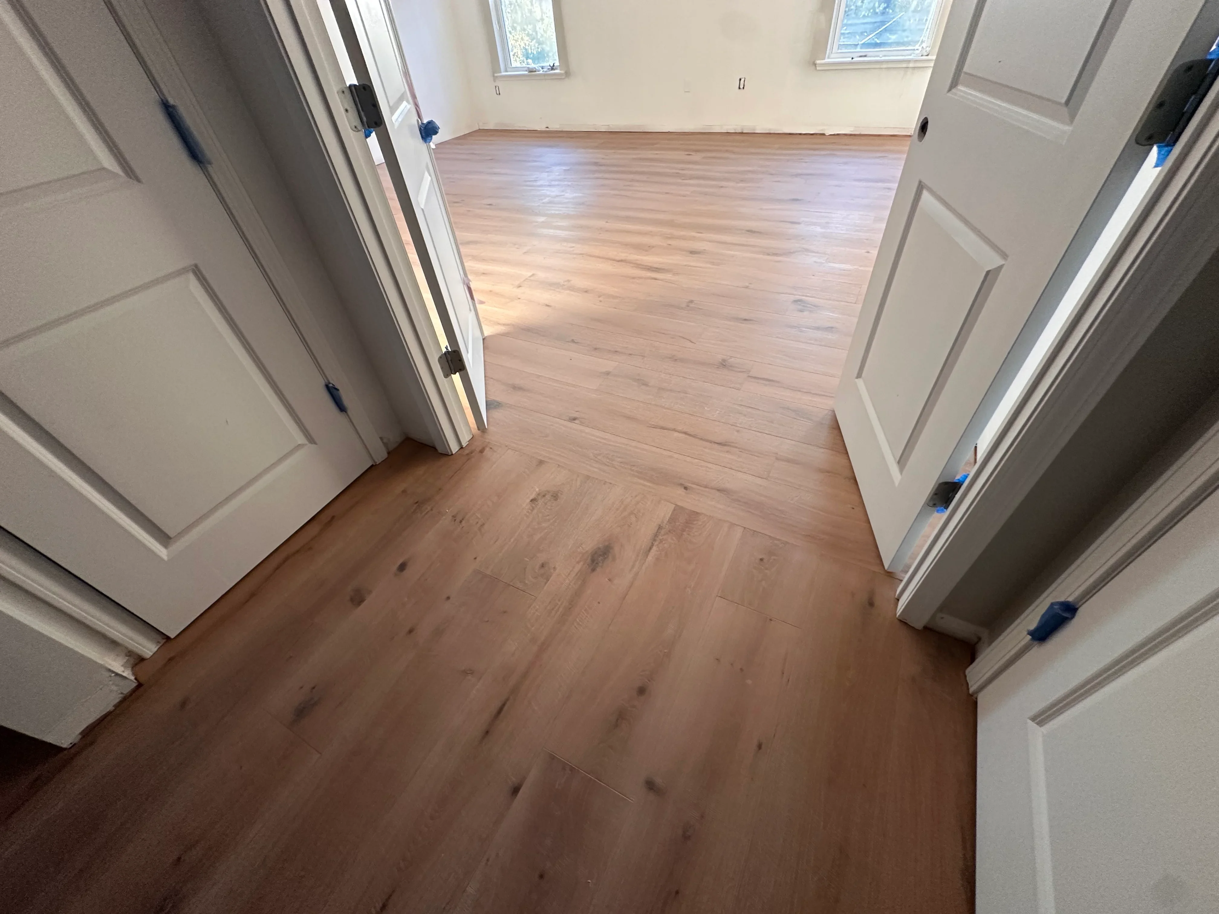 Newly installed hardwood flooring with warm wood tones throughout open residential space
