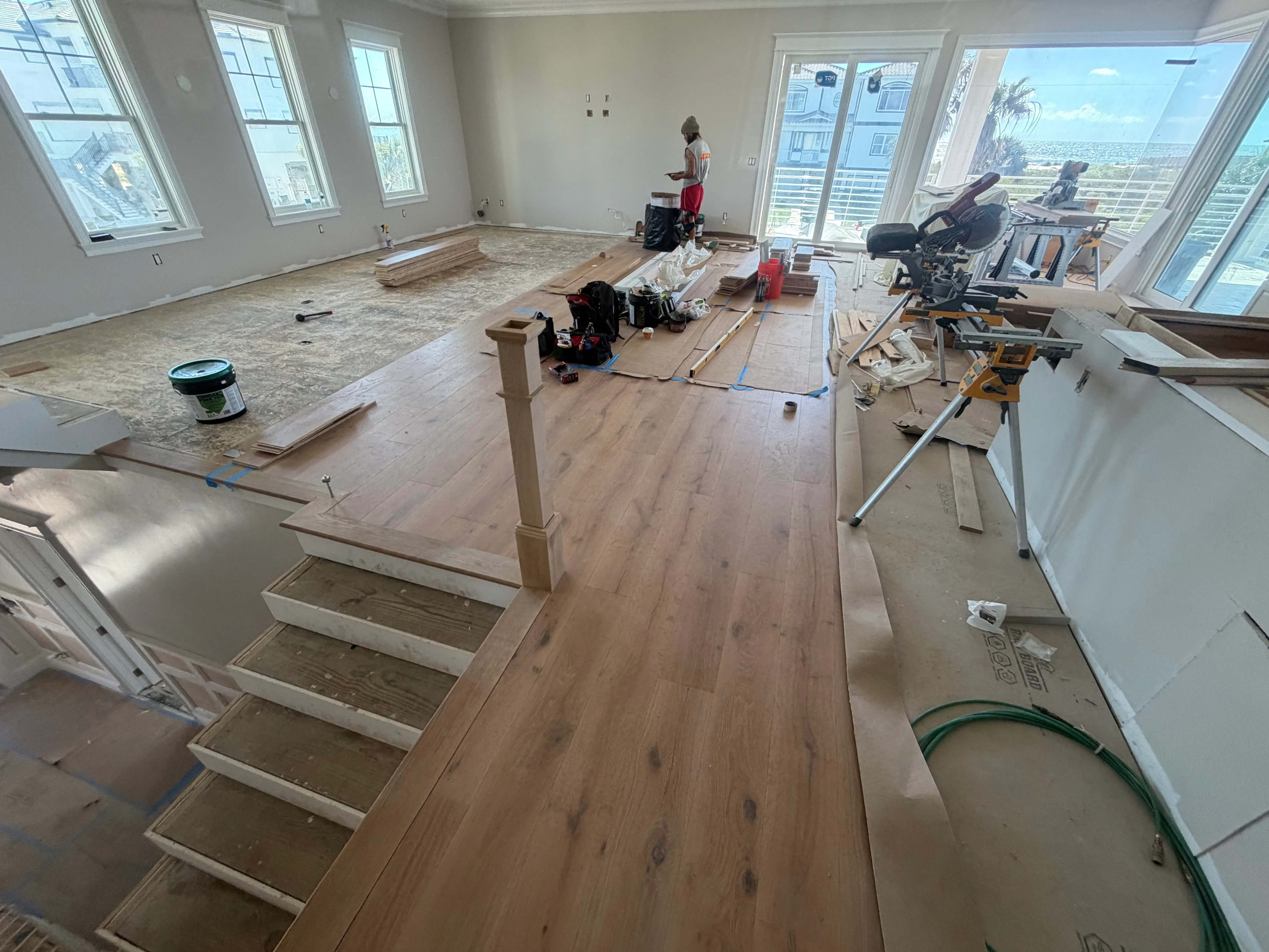 Luxury vinyl plank flooring installation in progress with protective underlayment and installation tools visible