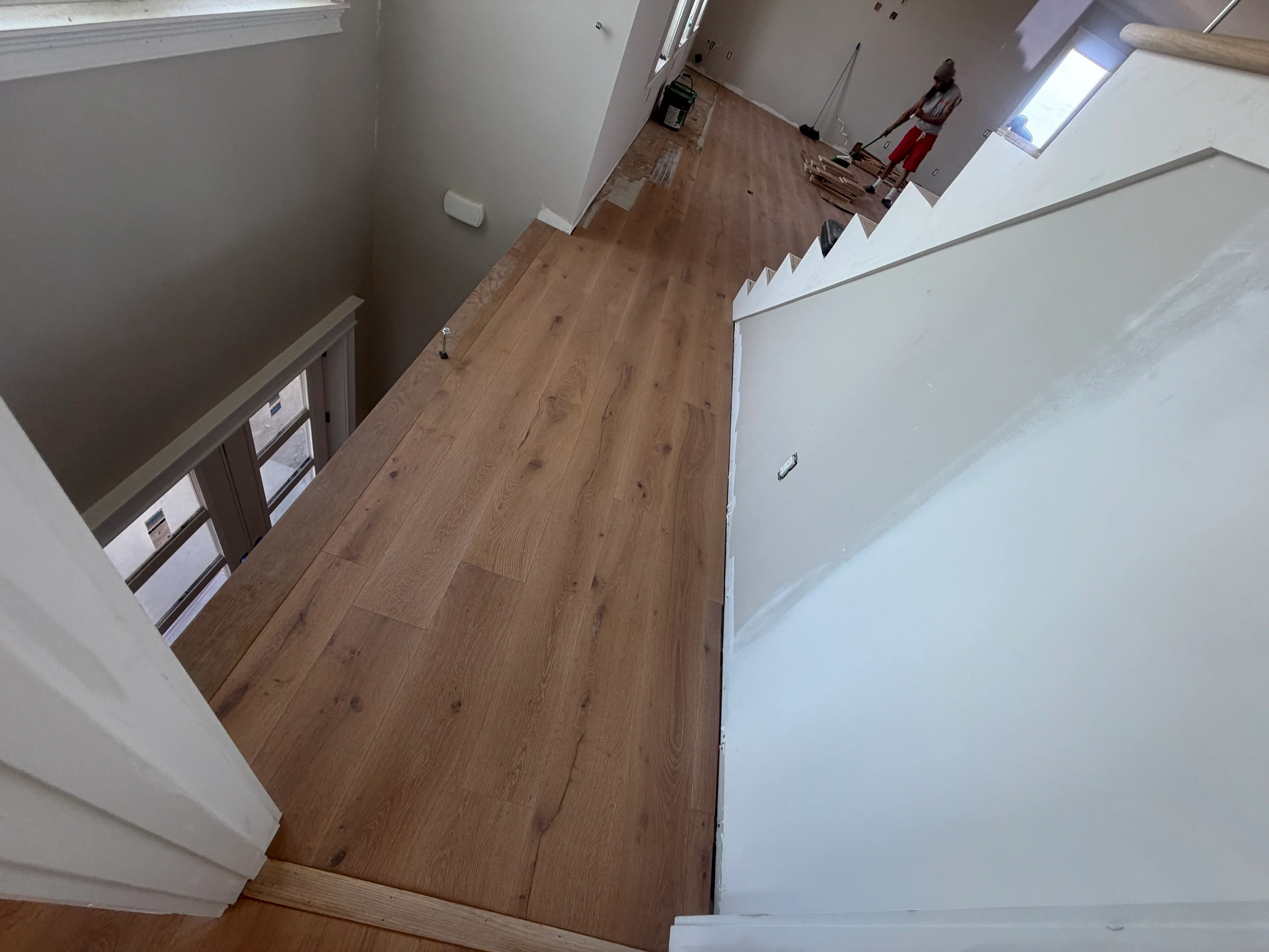 Wood-look luxury vinyl plank flooring installed in hallway with white walls and trim