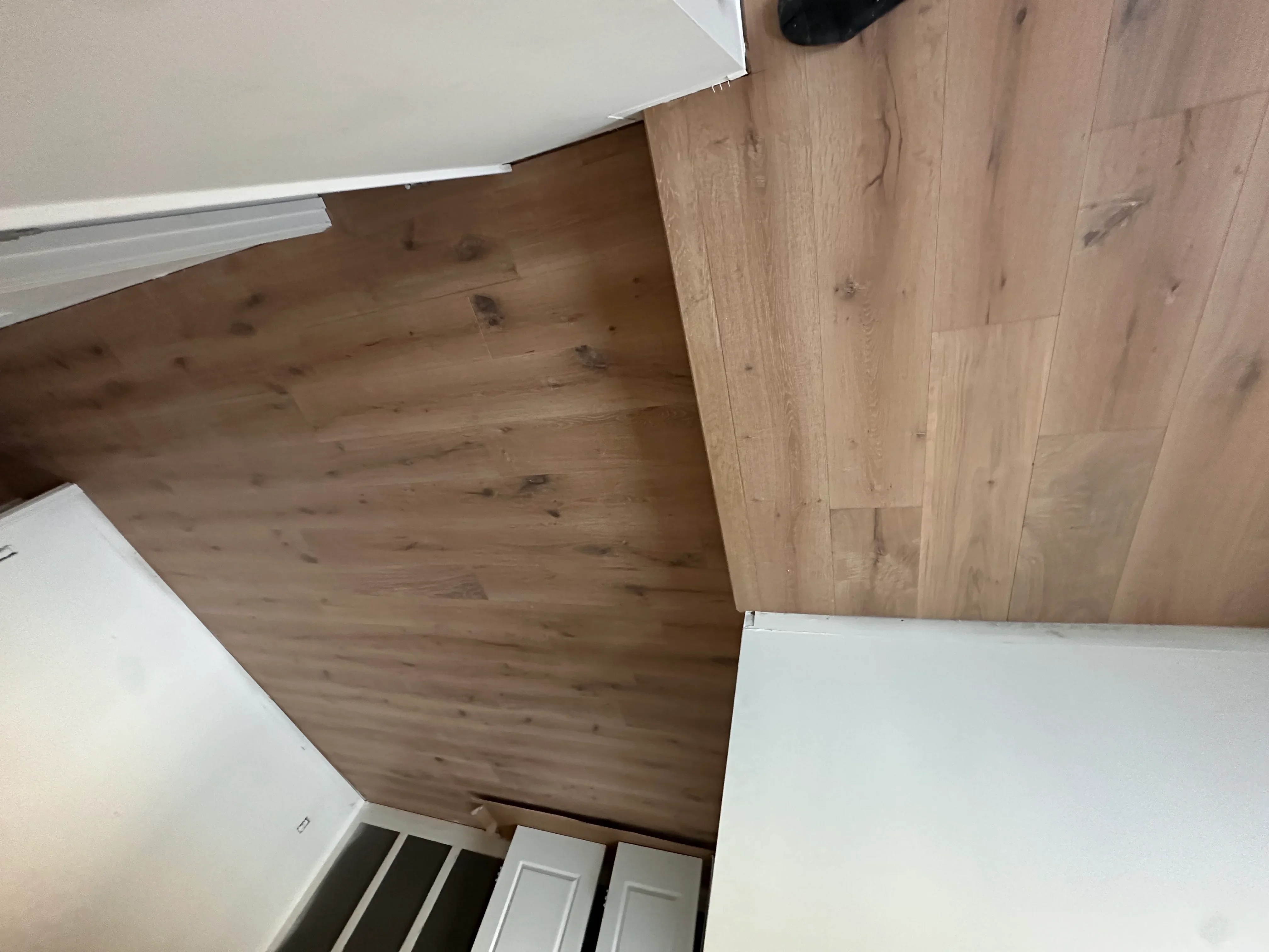 Luxury vinyl plank flooring with wood-grain finish and white baseboards installed in interior room