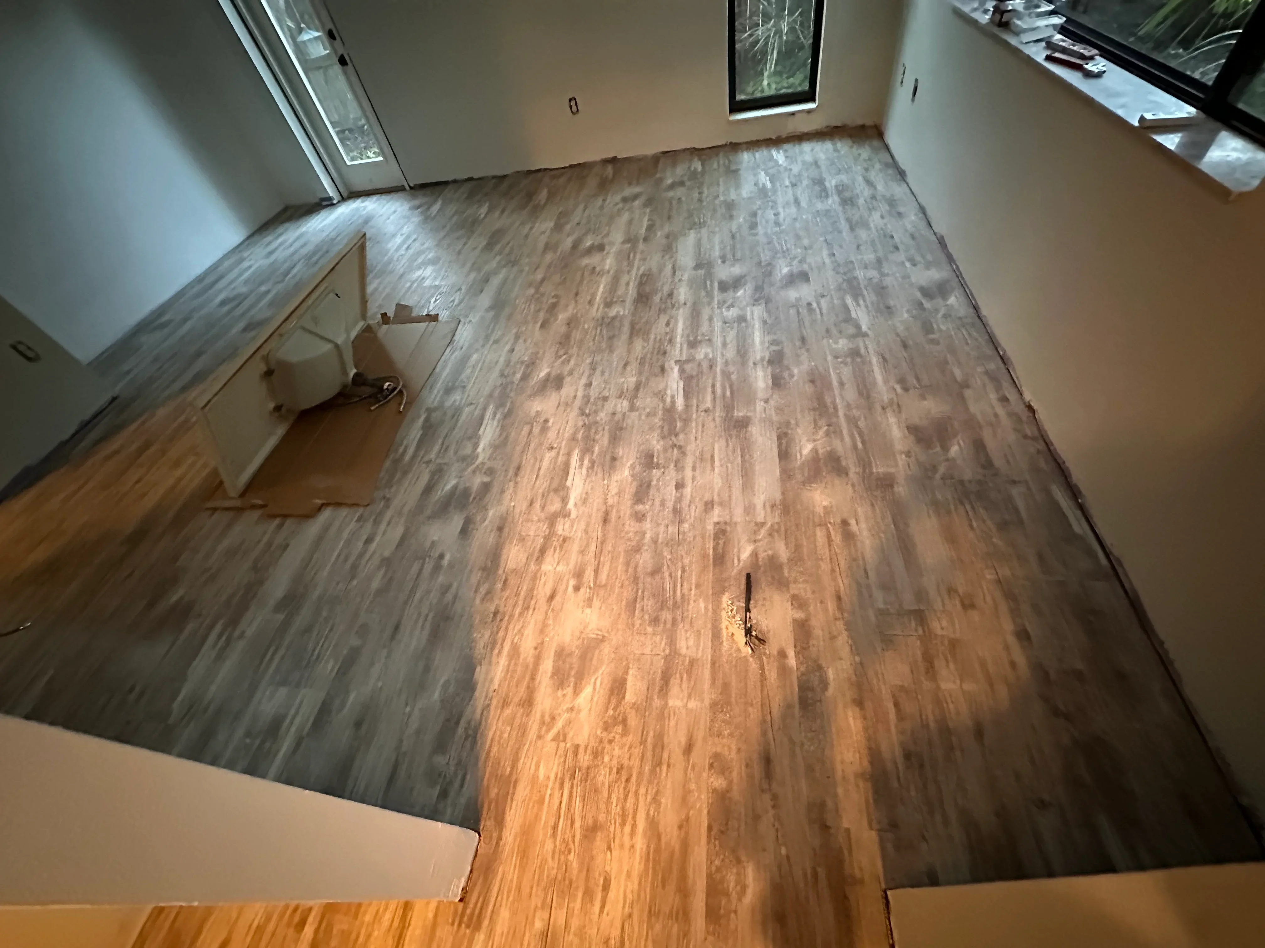 Luxury vinyl plank flooring with wood-grain pattern installed in kitchen