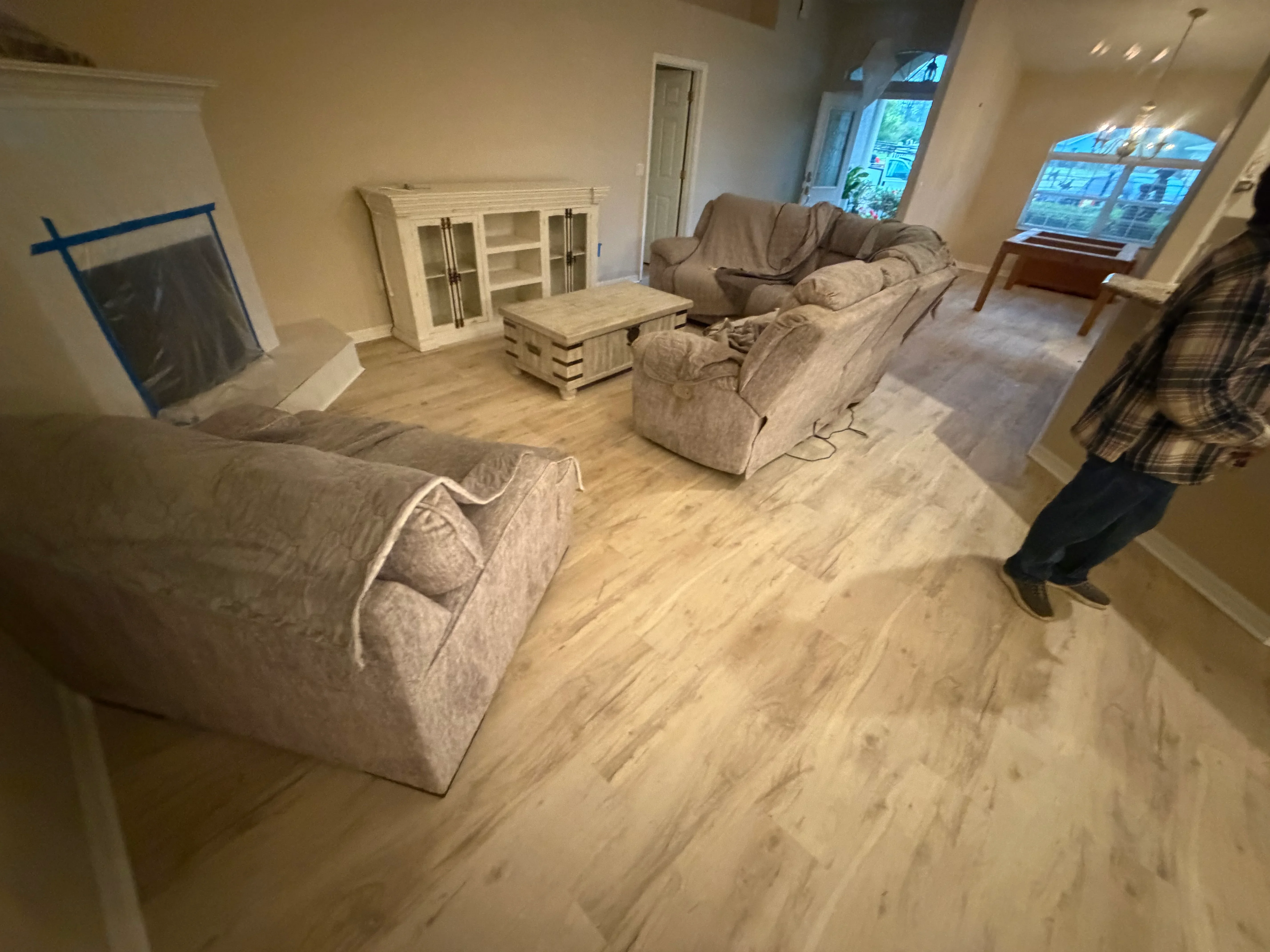 Luxury vinyl plank flooring installed in open living room with light wood tone finish