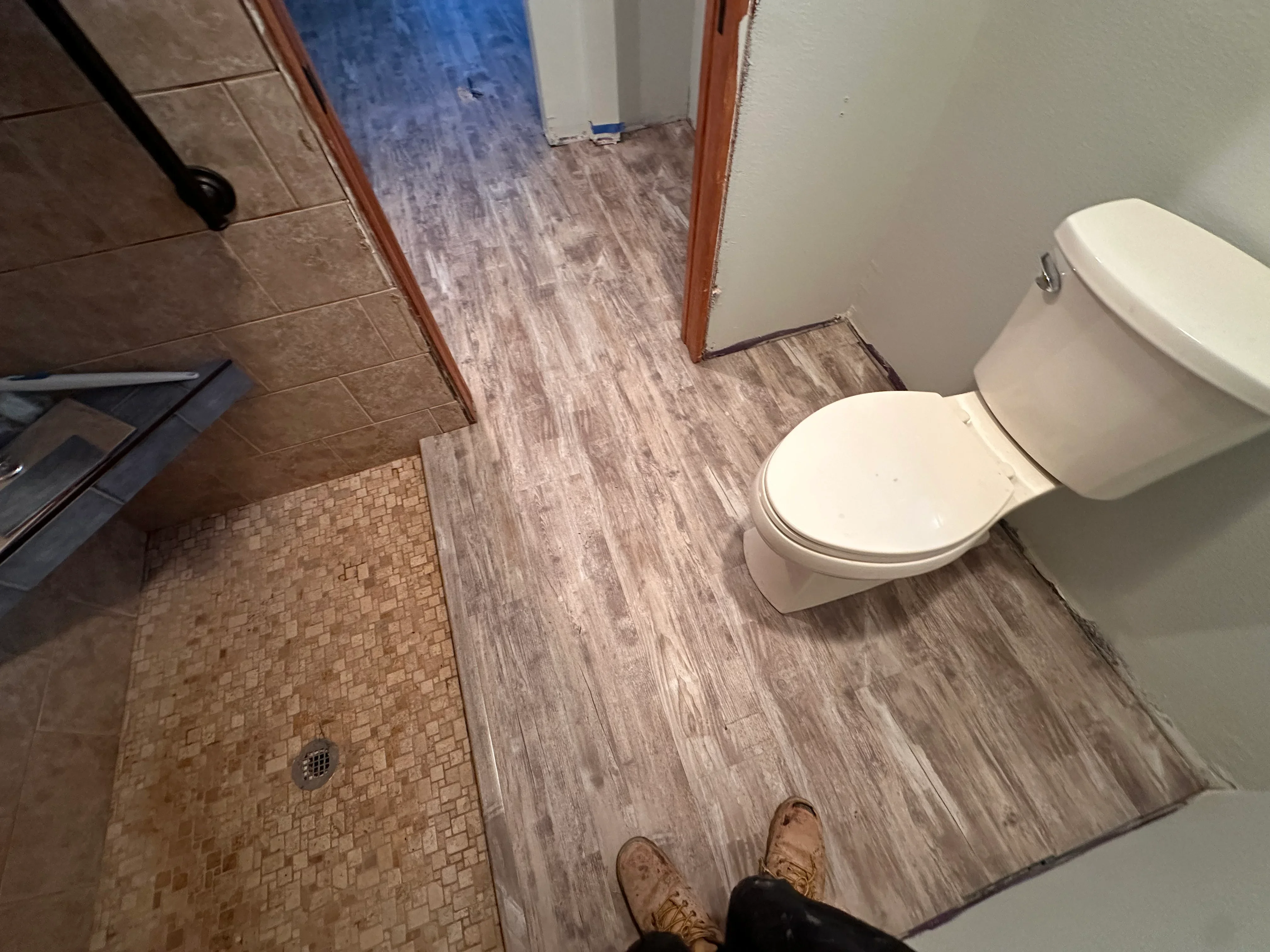Bathroom with wood-look tile flooring and mosaic shower tile installation